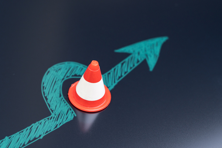 Chalk drawing arrow turn or break through road block traffic pylon on dark blackboard using as obstacle, solution for business problem or break through to success concept